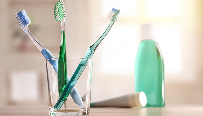 toothbrushes in a glass ready for oral hygiene by Townsville dentist